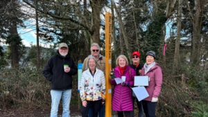 Rotarians standing with a peace pole